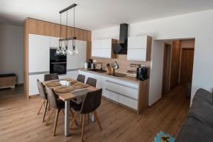a kitchen and dining room with a table and chairs at Apartmán Jesienka, Hillside in Dolný Kubín