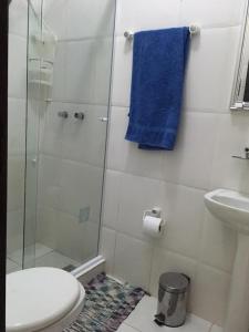 a bathroom with a toilet and a shower with a blue towel at Casa no paraíso ecológico da Ilha Grande in Abraão +22 photos