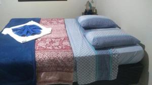 a bed with a blanket and a blue bow on it at Casa no paraíso ecológico da Ilha Grande in Abraão
