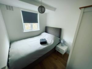 a bedroom with a bed with a clock on the wall at Mary Cottage, Braunton, Devon in Braunton