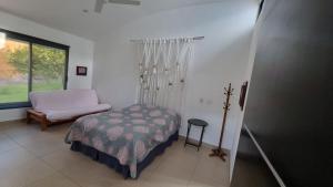 een slaapkamer met een bed, een stoel en een raam bij Kokopelli in Xochitepec