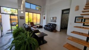 a living room with leather furniture and a staircase at Kokopelli in Xochitepec