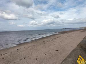 a beach with the ocean and a cloudy sky at Maze Beach Getaway in Ayr