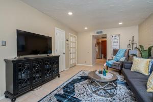 ein Wohnzimmer mit einem Sofa und einem Flachbild-TV in der Unterkunft Charming Condo in the Heart of Scottsdale in Scottsdale