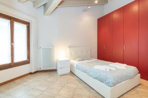 a bedroom with a bed with red cabinets and a window at Trilocale Rua Sovera 85 - F&L Aparment in Brescia