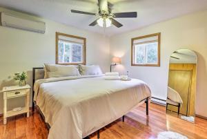 ein Schlafzimmer mit einem großen Bett und einem Deckenventilator in der Unterkunft Walk to Wolf Run Lake Cottage with Furnished Deck in Albrightsville