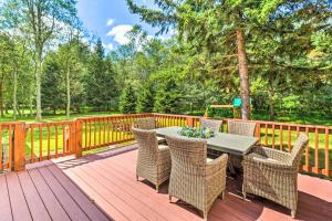 eine Terrasse mit einem Tisch und Stühlen auf einer Holzterrasse in der Unterkunft Walk to Wolf Run Lake Cottage with Furnished Deck in Albrightsville