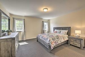 Schlafzimmer mit einem Bett, einer Kommode und Fenstern in der Unterkunft Glen Cove Home Walk to Boardwalk and Dining! in Glen Cove