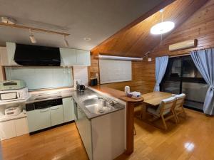 a kitchen with a sink and a table in it at HOCO Kawaguchiko in Azagawa