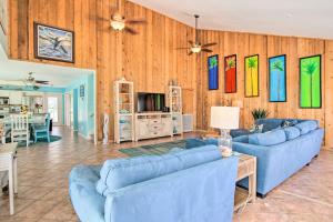 una sala de estar con muebles azules y paredes de madera. en Sunny South Padre Home - Steps to the Beach!, en South Padre Island