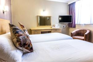 a hotel room with two beds and a television at Hotel De Normandie in Saint Helier Jersey