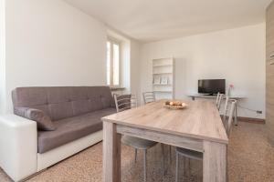 een woonkamer met een bank en een houten tafel bij Appartamento Piazza Garibaldi - F&L Apartment in Brescia