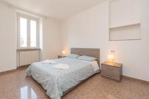 een slaapkamer met een groot bed en 2 nachtkastjes bij Appartamento Piazza Garibaldi - F&L Apartment in Brescia