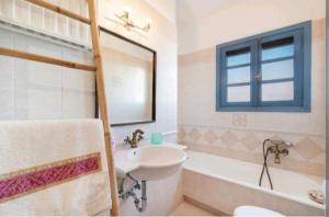 a white bathroom with a sink and a tub and a sink at Iris - Διαμέρισμα σε πολυκατοικία ως ολόκληρος χώρος in Souvala