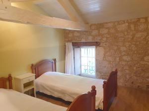 a bedroom with two beds and a window at Gite l'Herbier in Conne-de-Labarde