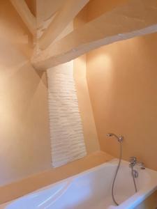 a bathroom with a bath tub with a window at Gite l'Herbier in Conne-de-Labarde