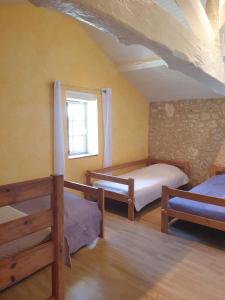 1 dormitorio con 2 camas y ventana en Gite l'Herbier en Conne-de-Labarde