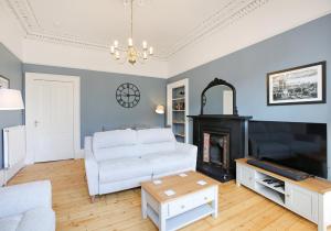 een woonkamer met een witte bank en een open haard bij The Newington Residence in Edinburgh