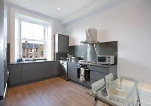 a kitchen with a stove and a sink and a microwave at The Newington Residence in Edinburgh