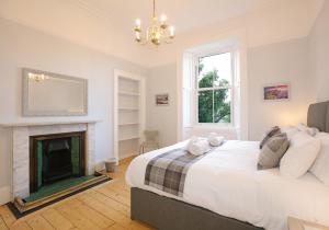 een slaapkamer met een bed en een open haard bij The Newington Residence in Edinburgh