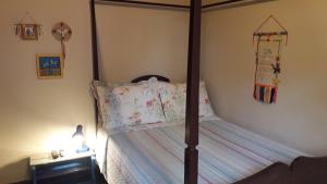 a bedroom with a four poster bed with a pillow at Poente Guest House in Conceição da Ibitipoca