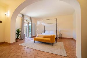 um quarto com uma cama de dossel e uma cadeira amarela em Palazzo Massaini - La Pieve em Pienza