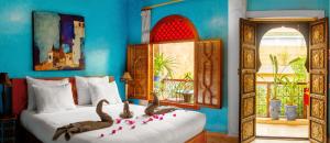 Un dormitorio con una cama con dos pájaros. en Riad Roxanne en Marrakech