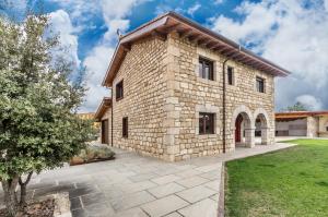 an exterior view of a stone house with a yard at Fidalsa Rest Station in Villadiego