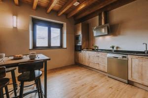 a kitchen with a counter and a table with chairs at Fidalsa Rest Station in Villadiego