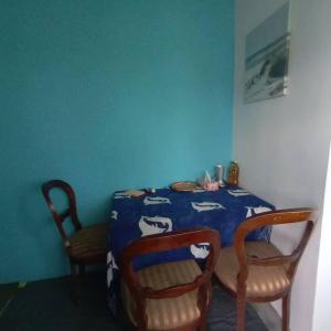 a dining room table with two chairs and a blue wall at Beach House in Kigamboni Dar es Salaam in Dar es Salaam