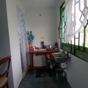 eine kleine Küche mit einem Waschbecken und einem Fenster in der Unterkunft Beach House in Kigamboni Dar es Salaam in Daressalam
