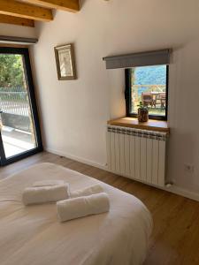 een slaapkamer met een groot wit bed en een raam bij Flora y Fauna. Casa de aldea / La playa y el bosque. Respira 