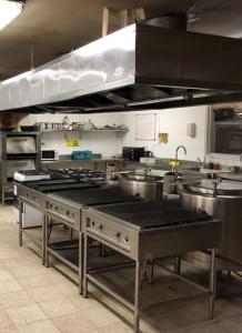 a large kitchen with stainless steel counters and sinks at Hotel Las Vicuñas in Putre
