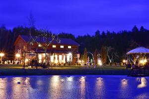 une maison la nuit avec un étang devant elle dans l'établissement Vila Forest Resort, 
