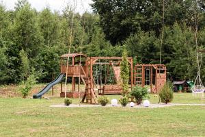 a playground in a park with two swings at Vila Forest Resort 