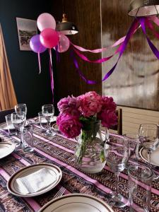 a table with a vase of flowers and balloons on it at Hotel Las Vicuñas in Putre