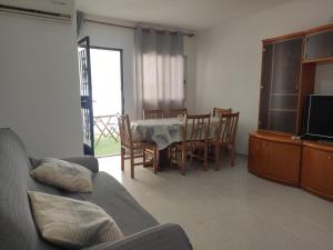 a living room with a table and chairs and a television at Apartamento rural Casa Calo 