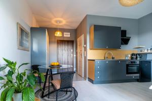 a kitchen with a table and chairs in a room at LIKE LAKES Ukiel Park 30 - Free parking FV in Olsztyn