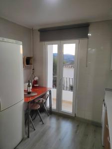 a kitchen with a table and a door with a balcony at Apartamento rural Casa Calo 