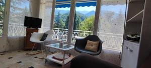 a living room with two chairs and a large window at Refuge Arago by Les Demeures de Rachel in Vernet-les-Bains