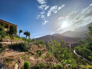 AdaZen Ecolodge في أزيلال: اطلاله على الجبال مع الشمس في السماء