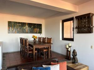 a dining room with a wooden table and chairs at Cousy Condo in the historic center of San Miguel de Allende, incredible view, pool, BBQ, 3 blocks from the main parish in San Miguel de Allende