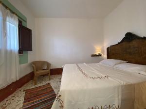 a bedroom with a large bed and a chair at Macaseni Di Franca in Scopello