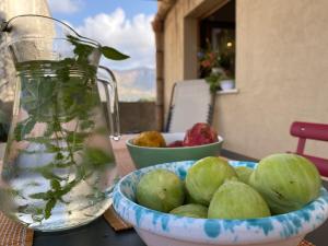 a bowl of fruit and a jar of water on a table at Macaseni Di Franca in Scopello