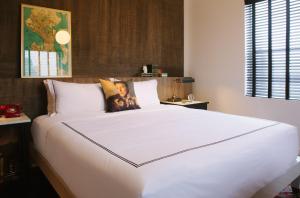 a large bed in a bedroom with a large white bedspread at Kimpton Palladian Hotel, an IHG Hotel in Seattle