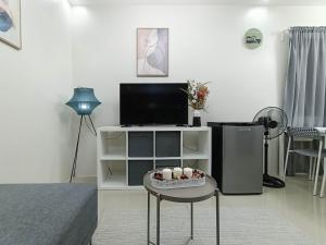馬比尼的住宿－Manzil Anilao B&B，客厅配有电视和一张带鸡蛋的桌子。