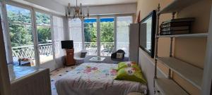 a bedroom with a bed and a balcony with windows at Refuge Arago in Vernet-les-Bains