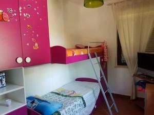 Dormitorio infantil con litera y escalera en Villa Elios, en Gizzeria