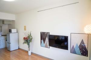 een keuken met een witte muur en een flatscreen-tv bij Bios Hall / Vacation STAY 2175 in Sapporo