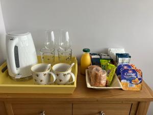 a table with cups and other items on it at Sirens Sunset Peaceful Retreat with stunning sea views, 5 minutes from Porth Beach in Newquay
